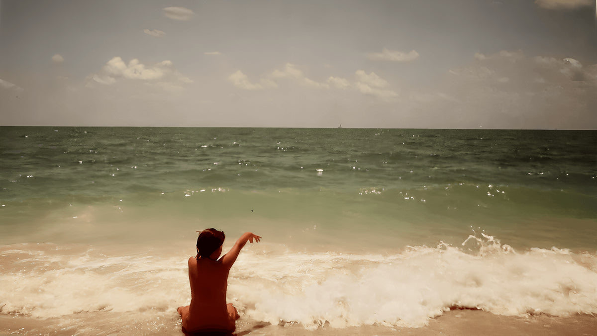 Francine Sharrocks as a child sitting at the edge of the sea